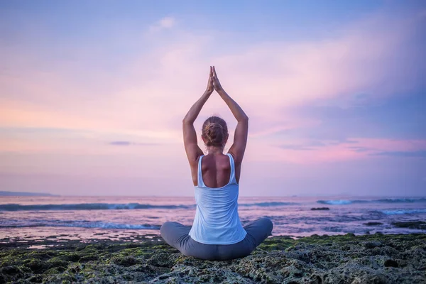 Kaukasische Frau praktiziert Yoga an der Küste — Stockfoto
