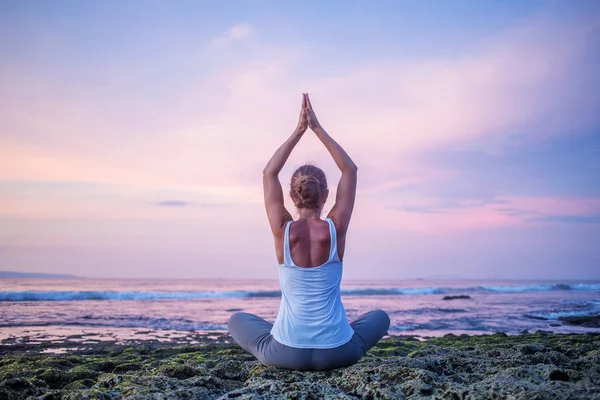 Mujer caucásica practicando yoga en la orilla del mar — Foto de Stock