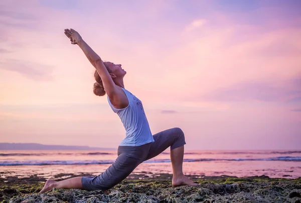 Kaukasisk kvinna utövar yoga på stranden — Stockfoto