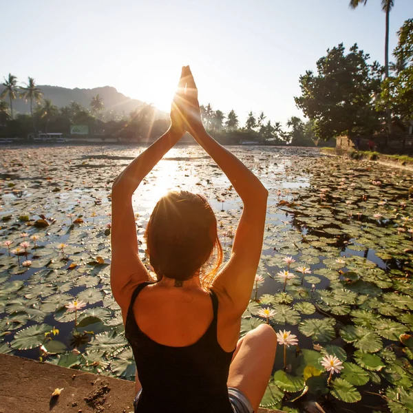 Donna pratica yoga su un lago con ninfee di loto — Foto Stock