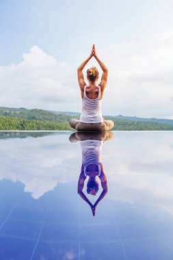 Beyaz kadın havuz tarafından Yoga pratik