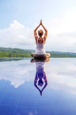 Beyaz kadın havuz tarafından Yoga pratik