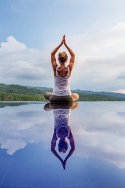 Beyaz kadın havuz tarafından Yoga pratik