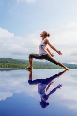 Beyaz kadın havuz tarafından Yoga pratik