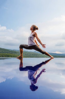 Beyaz kadın havuz tarafından Yoga pratik