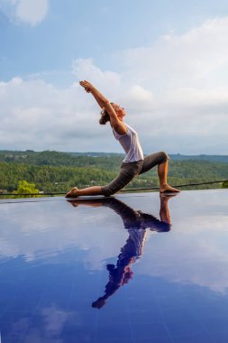 Beyaz kadın havuz tarafından Yoga pratik