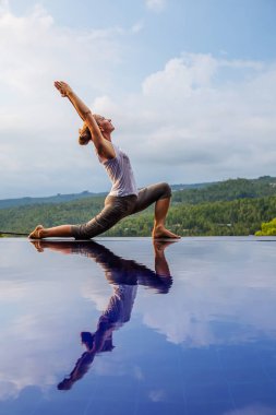 Beyaz kadın havuz tarafından Yoga pratik