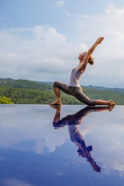 Beyaz kadın havuz tarafından Yoga pratik