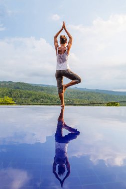 Beyaz kadın havuz tarafından Yoga pratik