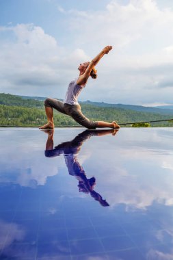 Beyaz kadın havuz tarafından Yoga pratik