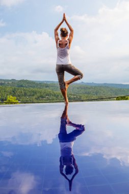 Beyaz kadın havuz tarafından Yoga pratik