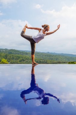 Beyaz kadın havuz tarafından Yoga pratik