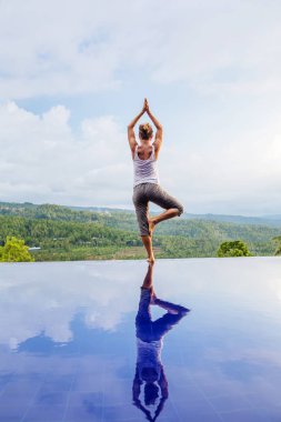 Beyaz kadın havuz tarafından Yoga pratik