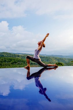 Beyaz kadın havuz tarafından Yoga pratik