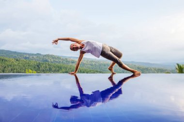 Beyaz kadın havuz tarafından Yoga pratik