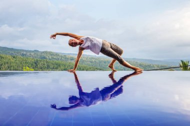 Beyaz kadın havuz tarafından Yoga pratik