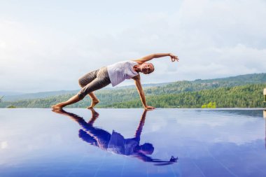 Beyaz kadın havuz tarafından Yoga pratik