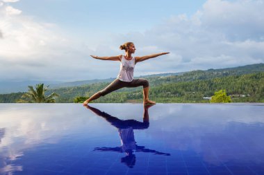 Beyaz kadın havuz tarafından Yoga pratik