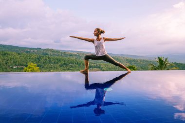 Beyaz kadın havuz tarafından Yoga pratik