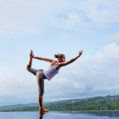 Beyaz kadın havuz tarafından Yoga pratik