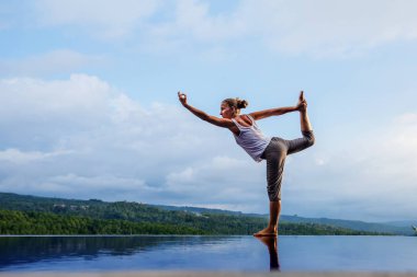 Beyaz kadın havuz tarafından Yoga pratik