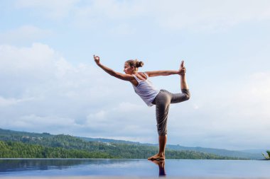 Beyaz kadın havuz tarafından Yoga pratik