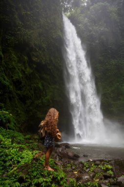 Woman near Nung Nung waterfal on Bali, Indonesia