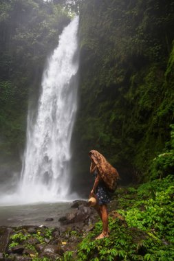 Woman near Nung Nung waterfal on Bali, Indonesia