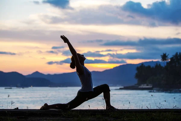 Mujer caucásica practicando yoga en la orilla del mar — Foto de Stock