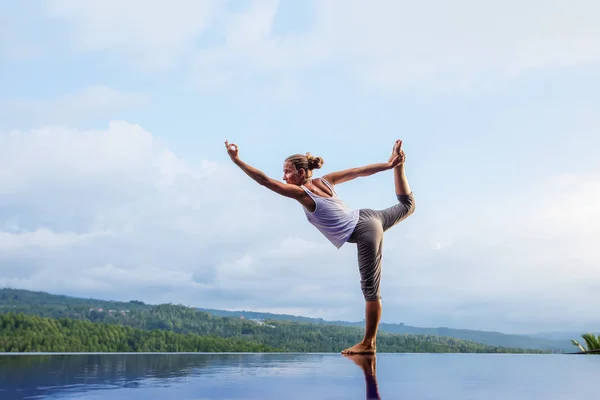 Kaukasische vrouw het beoefenen van yoga bij het zwembad — Stockfoto