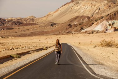 ABD'de bir yolda yürüyen otostopçu kadın