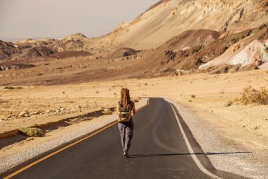 ABD'de bir yolda yürüyen otostopçu kadın