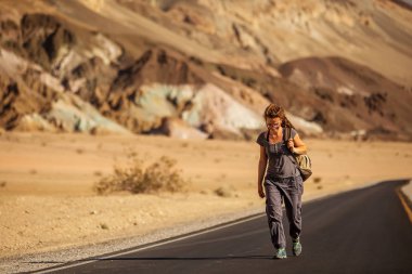 ABD'de bir yolda yürüyen otostopçu kadın