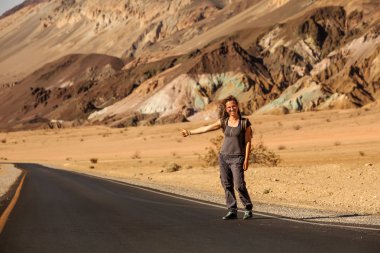 ABD'de bir yolda yürüyen otostopçu kadın