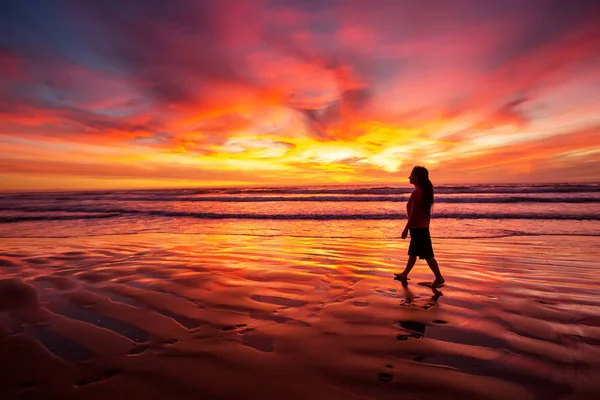 Mujer caminando sola en la playa al atardecer —  Fotos de Stock