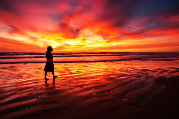 Donna che cammina da sola sulla spiaggia al tramonto — Foto Stock