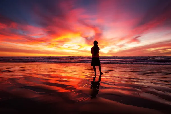 Mujer caminando sola en la playa al atardecer —  Fotos de Stock