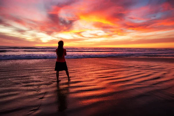 Wanita berjalan sendirian di pantai saat matahari terbenam — Stok Foto