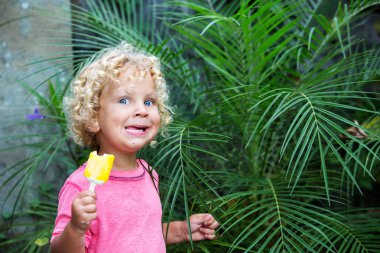  sarışın kıvırcık saçlı küçük çocuk dondurma yiyor 