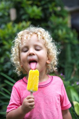  sarışın kıvırcık saçlı küçük çocuk dondurma yiyor 
