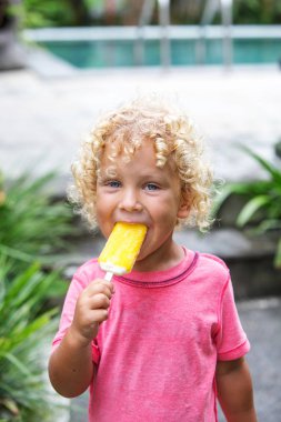  sarışın kıvırcık saçlı küçük çocuk dondurma yiyor 