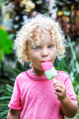  sarışın kıvırcık saçlı küçük çocuk dondurma yiyor 