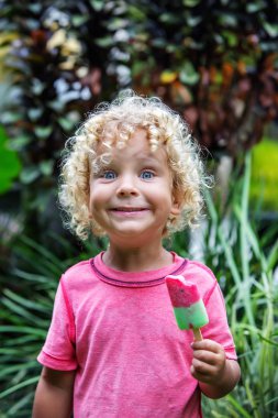  sarışın kıvırcık saçlı küçük çocuk dondurma yiyor 