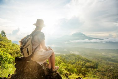 Batur, Bali, Indon dağının tepesinden gün doğumunun tadını çıkaran kadın