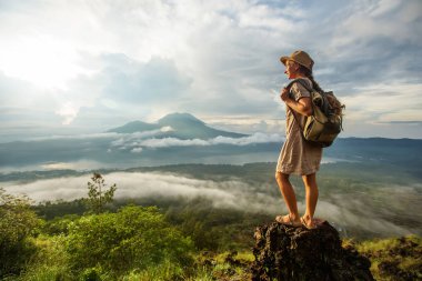 Batur, Bali, Indon dağının tepesinden gün doğumunun tadını çıkaran kadın