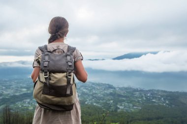 Batur, Bali, Indon dağının tepesinden gün doğumunun tadını çıkaran kadın