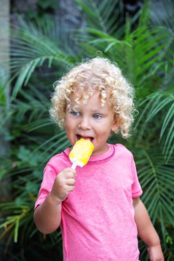  sarışın kıvırcık saçlı küçük çocuk dondurma yiyor 
