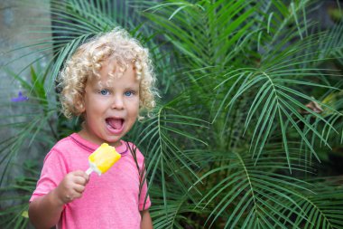  sarışın kıvırcık saçlı küçük çocuk dondurma yiyor 