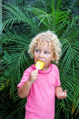  sarışın kıvırcık saçlı küçük çocuk dondurma yiyor 
