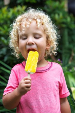  sarışın kıvırcık saçlı küçük çocuk dondurma yiyor 